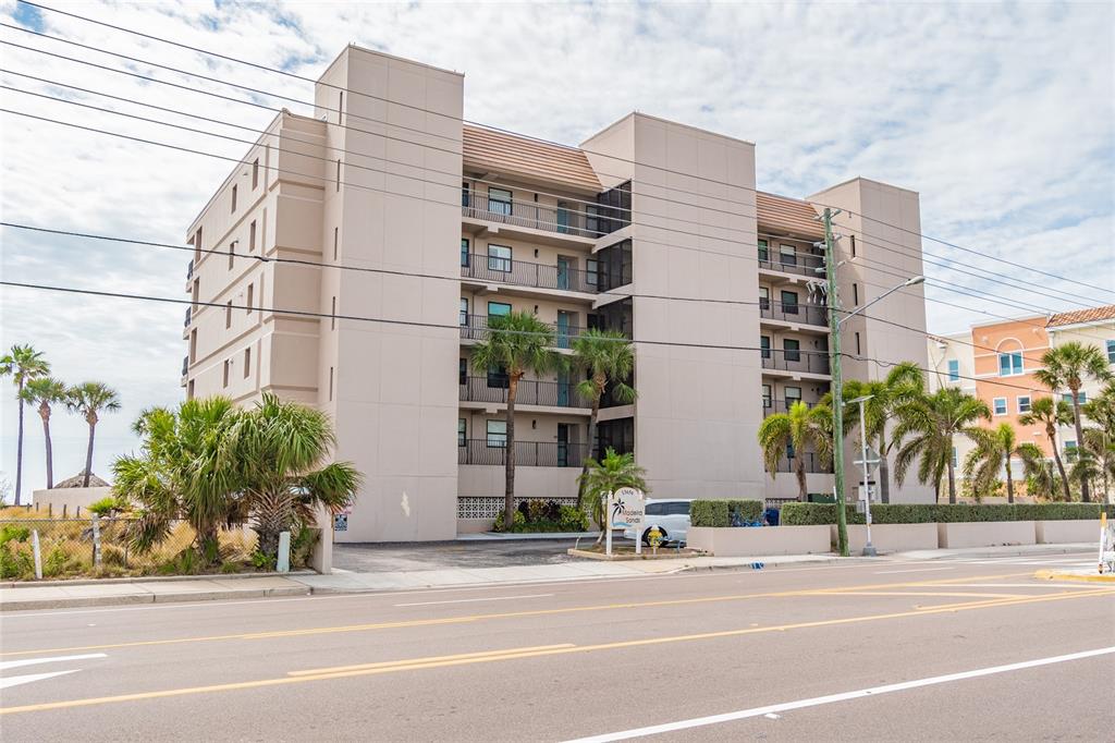 13650 Gulf Boulevard, Unit 402 Madeira Beach, FL 33708 - Photo 39 of 44 a tall building sitting on the side of a street