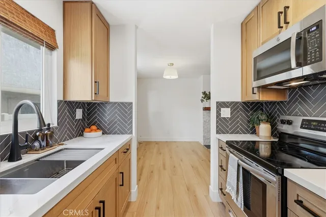 a kitchen with stainless steel appliances granite countertop a sink stove and microwave