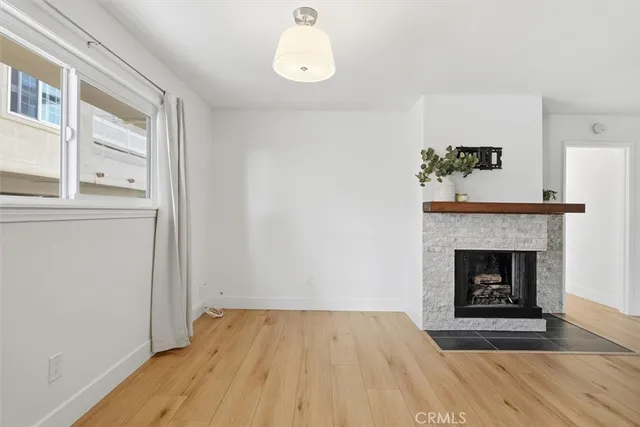 a view of empty room with wooden floor and fireplace