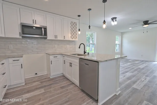 a kitchen with white cabinets and stainless steel appliances