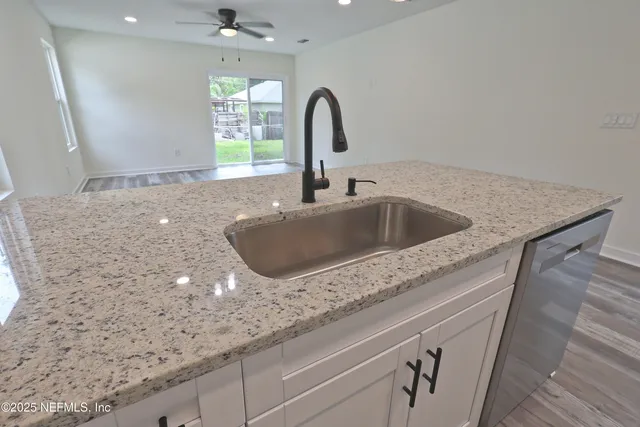 a view of an empty room and kitchen view