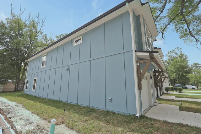 a view of a house with backyard and tree