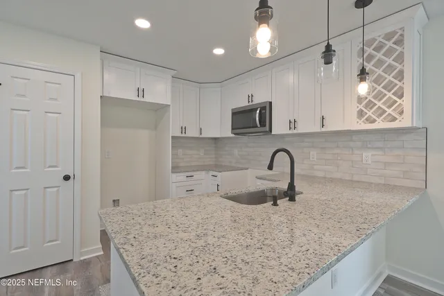 a kitchen with white cabinets stainless steel appliances and sink