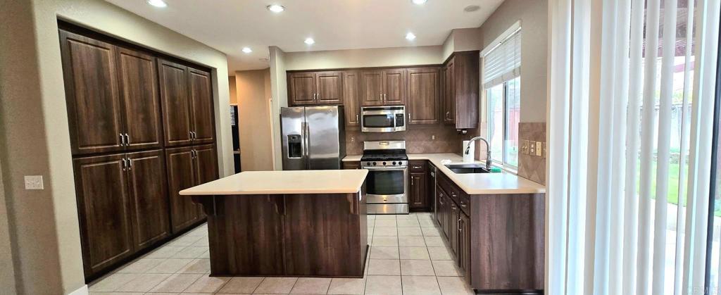 5071 Avocado Park Way Fallbrook, CA 92028 - Photo 2 of 7 a kitchen with stainless steel appliances kitchen island granite countertop a refrigerator and a sink
