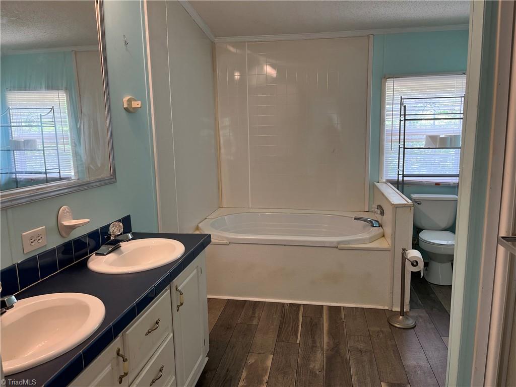 4118 Hubbard Road Winston-Salem, NC 27101 - Photo 7 of 14 Primary bath, dual sinks, soaking tub, and separate shower.