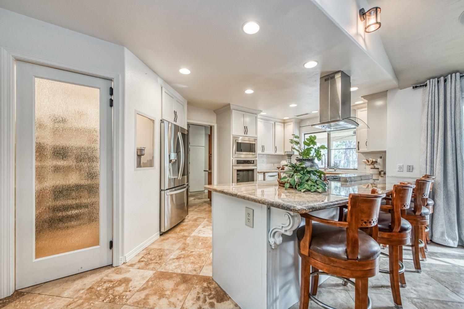 12592 Auberry Road Clovis, CA 93619 - Photo 12 of 65 a kitchen with stainless steel appliances kitchen island granite countertop a refrigerator and microwave