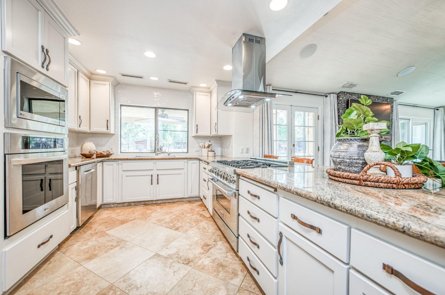 12592 Auberry Road Clovis, CA 93619 - Photo 13 of 65 a large kitchen with stainless steel appliances lots of counter space wooden floor and a sink