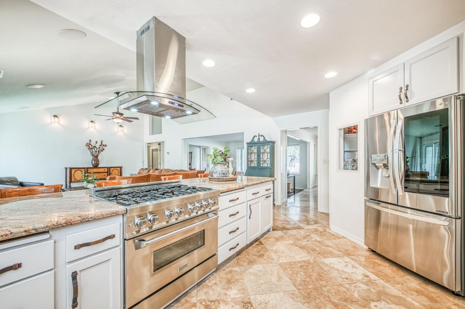 12592 Auberry Road Clovis, CA 93619 - Photo 15 of 65 a kitchen with stainless steel appliances granite countertop a stove and a refrigerator