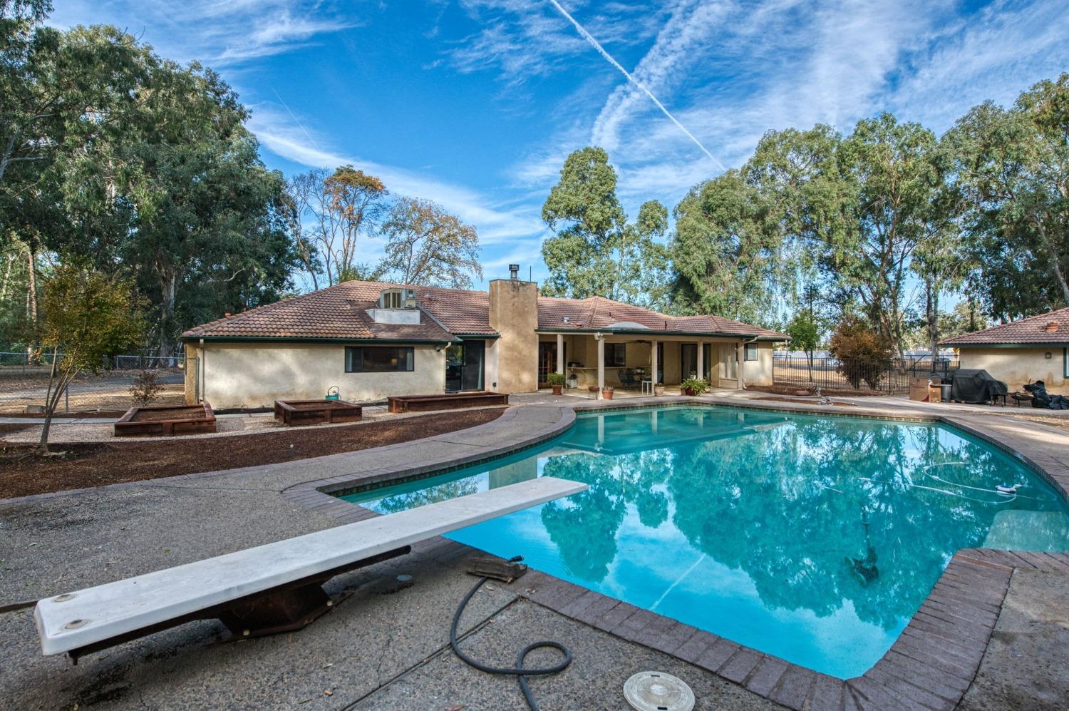 12592 Auberry Road Clovis, CA 93619 - Photo 32 of 65 a front view of a house with a yard table and chairs