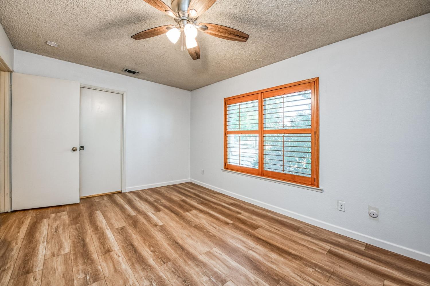12592 Auberry Road Clovis, CA 93619 - Photo 39 of 65 a view of an empty room with a window and a chandelier fan