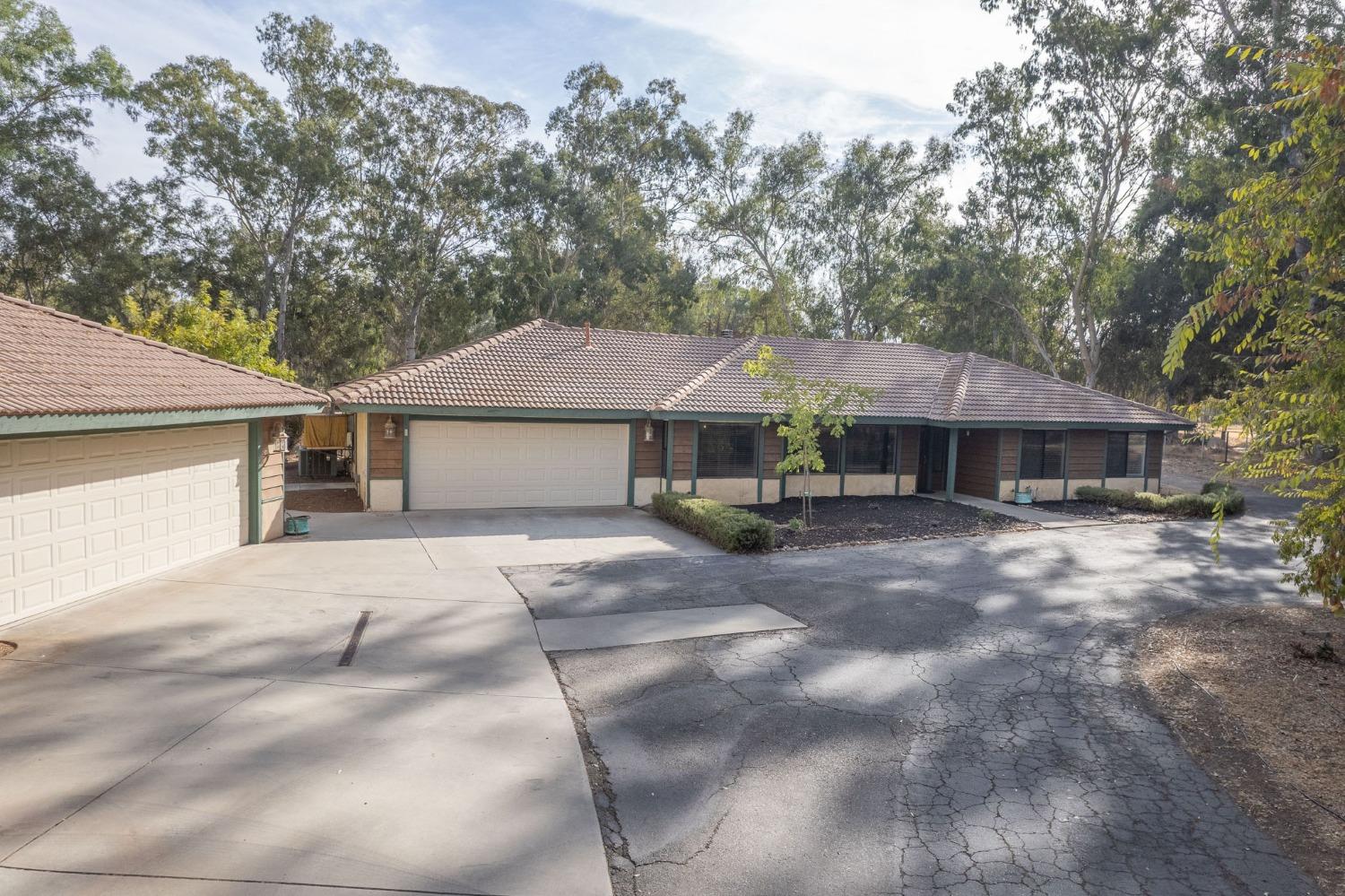 12592 Auberry Road Clovis, CA 93619 - Photo 45 of 65 a front view of a house with a garden and trees