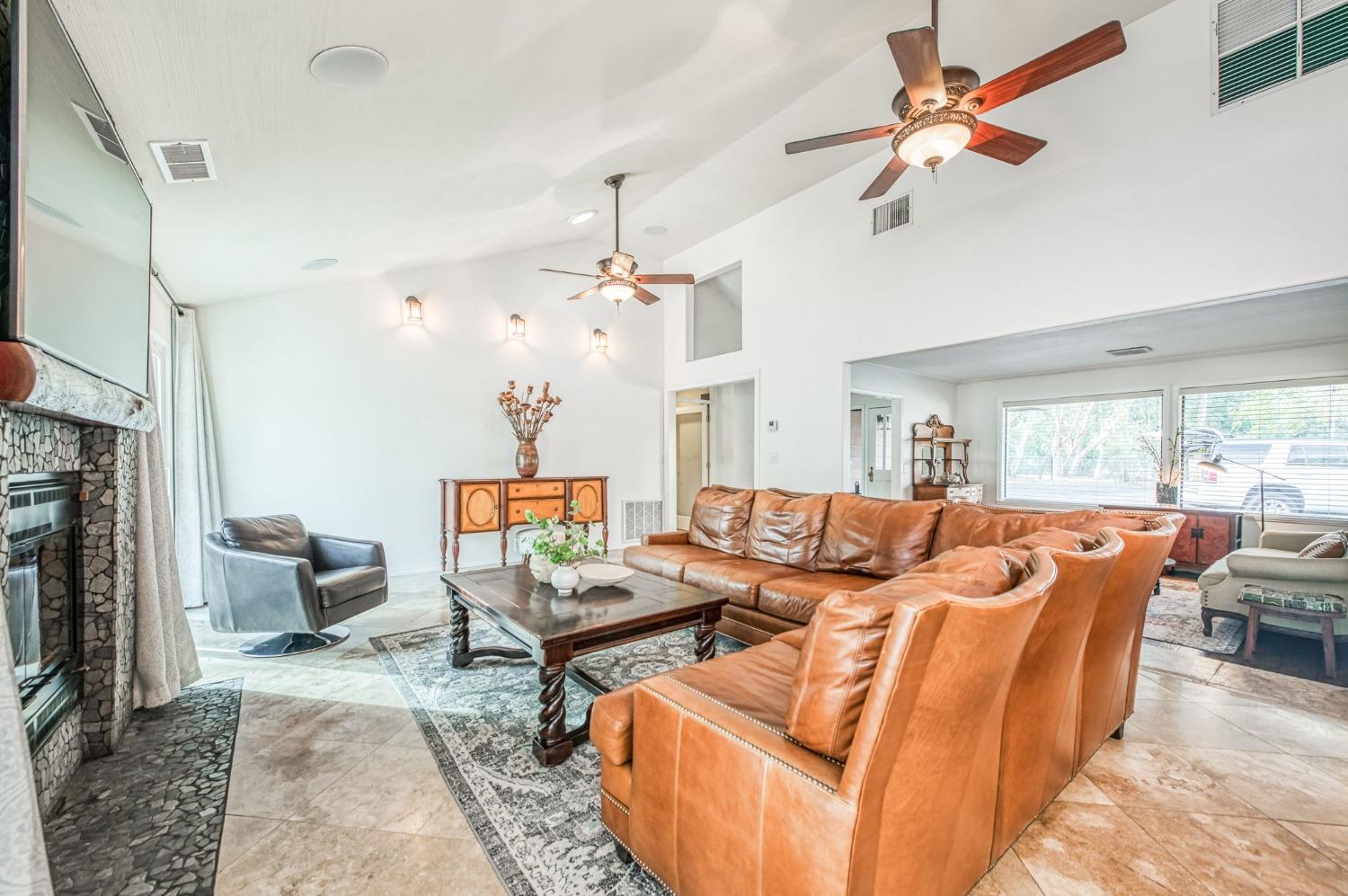 12592 Auberry Road Clovis, CA 93619 - Photo 5 of 65 a living room with furniture a chandelier and a fireplace
