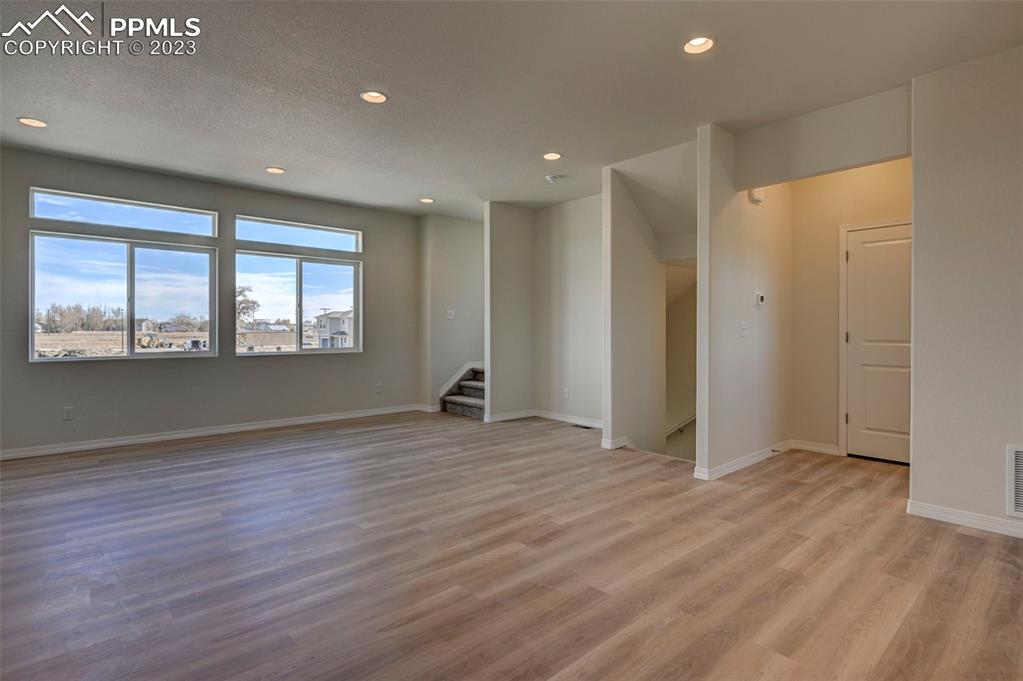 11270 Feliz Way Fountain, CO 80817 - Photo 21 of 42 an empty room with wooden floor and windows