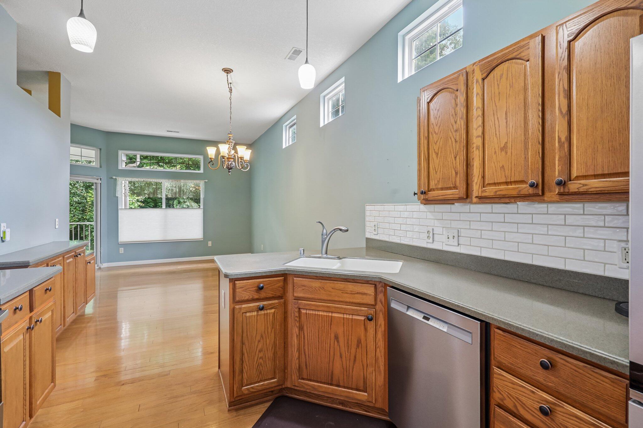 876 Flint Ridge Newport, KY 41076 - Photo 20 of 43 Open-concept kitchen featuring wood-finish cabinetry, a corner sink with a stainless steel faucet, and a subway tile backsplash