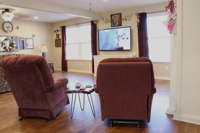 a living room with couches painting on the wall and a large window