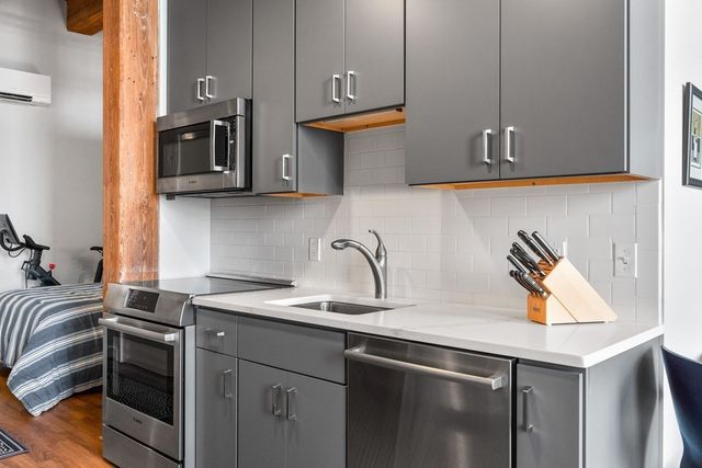 a kitchen with stainless steel appliances granite countertop a sink and a stove