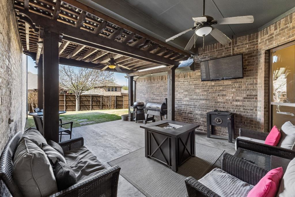 3917 Gatewick Drive Rockwall, TX 75087 - Photo 26 of 34 a living room with furniture a fireplace and a flat screen tv