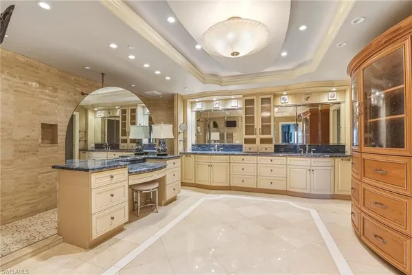 a large kitchen with stainless steel appliances a large counter top and cabinets