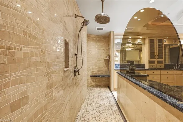 a spacious bathroom with a granite countertop sink a mirror and a bathtub