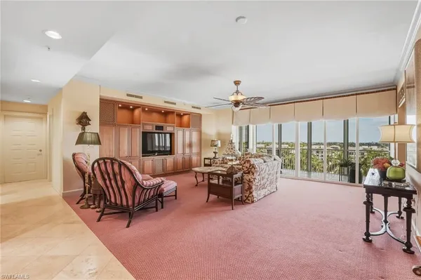 a living room with furniture and a floor to ceiling window