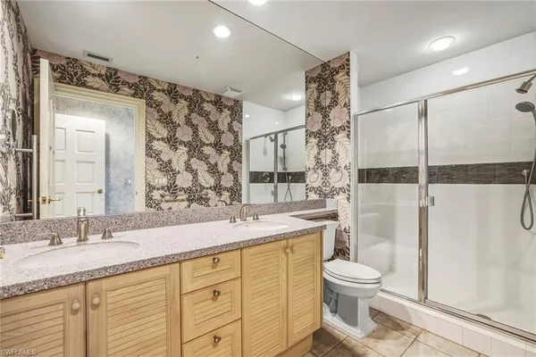 a bathroom with a granite countertop sink toilet and shower