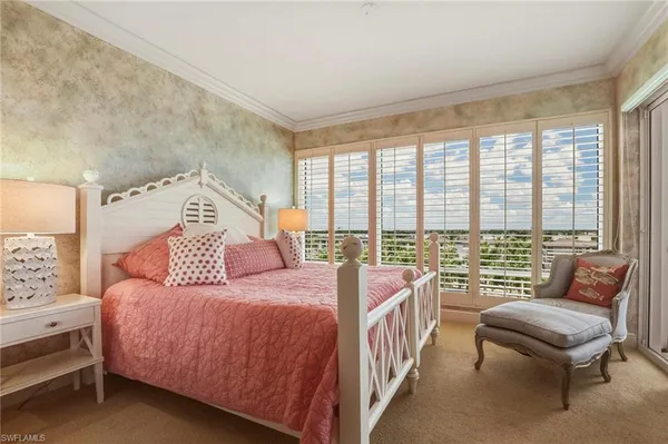 a bedroom with a bed and a couch next to a window