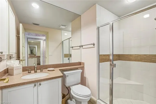 a bathroom with a granite countertop sink toilet and shower