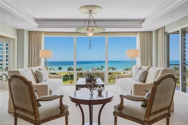 a living room with furniture a chandelier and a window
