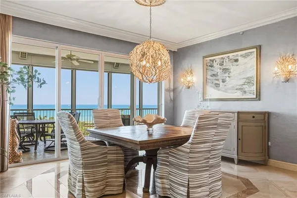 a dining room with furniture a chandelier and wooden floor