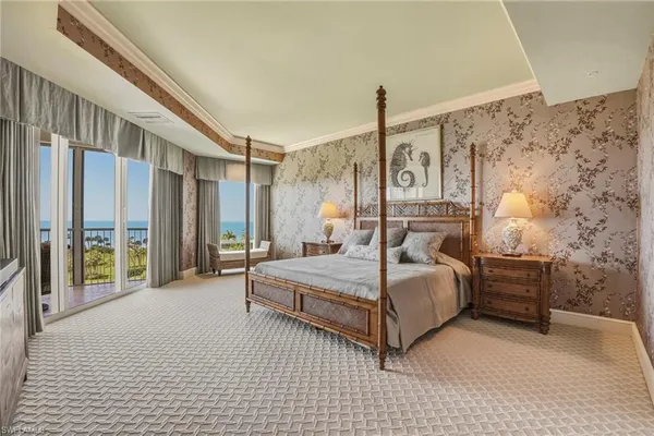 a bedroom with a bed couch and a large window