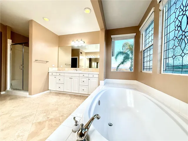 a spacious bathroom with a tub sink and mirror