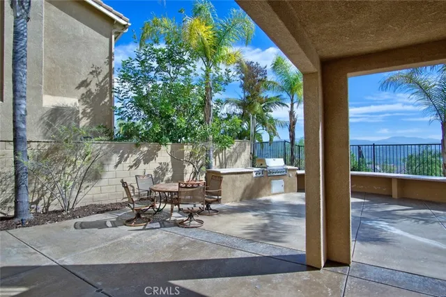 a view of a patio with table and chairs potted plants with wooden floor and fence