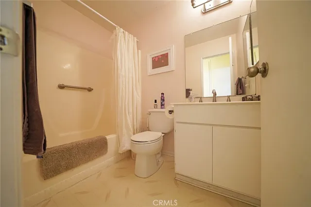 a bathroom with a granite countertop sink a toilet and shower