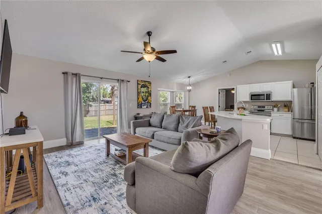 a living room with furniture kitchen view and a window