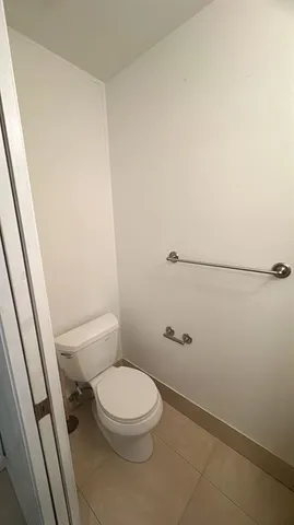 a white toilet sitting next to a shower