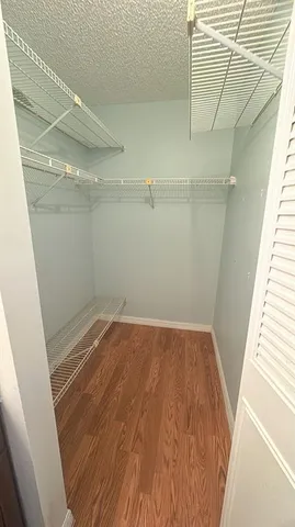 a view of a room with wooden floor and white walls