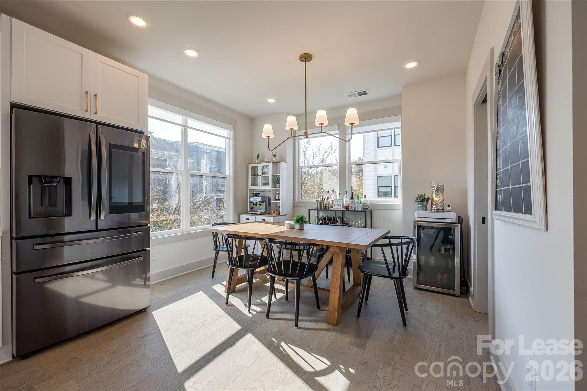 2319 Wesley Village Road Charlotte, NC 28208 - Photo 11 of 44 a kitchen with kitchen island a dining table chairs and refrigerator
