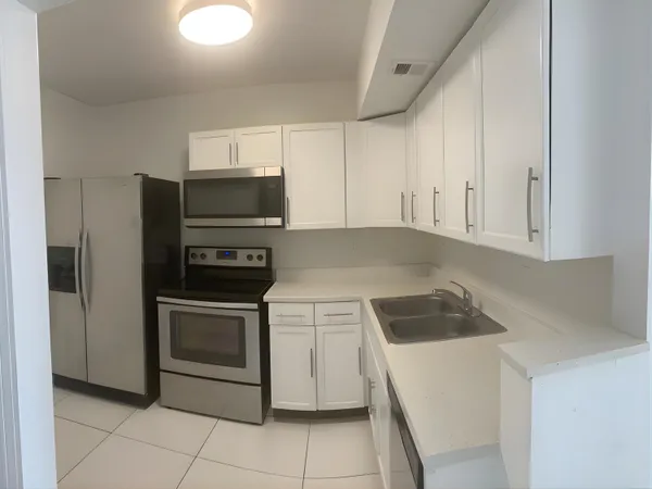 a kitchen with white cabinets and stainless steel appliances