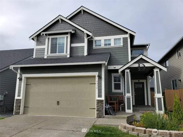 a front view of a house with a yard and garage