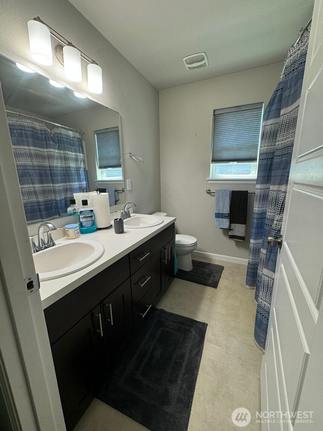 9976 Charles Street Southeast Yelm, WA 98597 - Photo 10 of 30 a bathroom with a double vanity sink a mirror and a toilet
