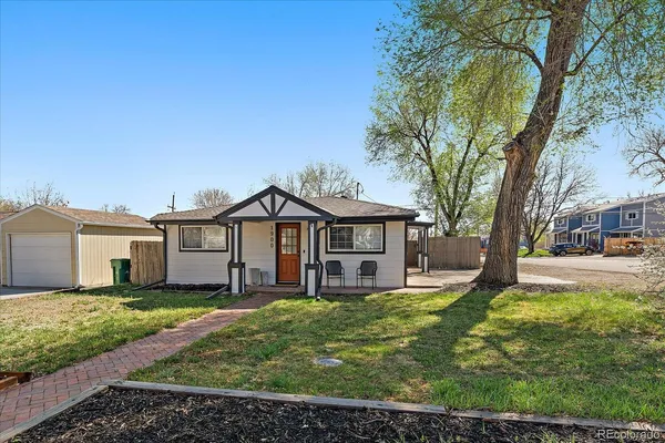 a view of a house with a big yard and large tree