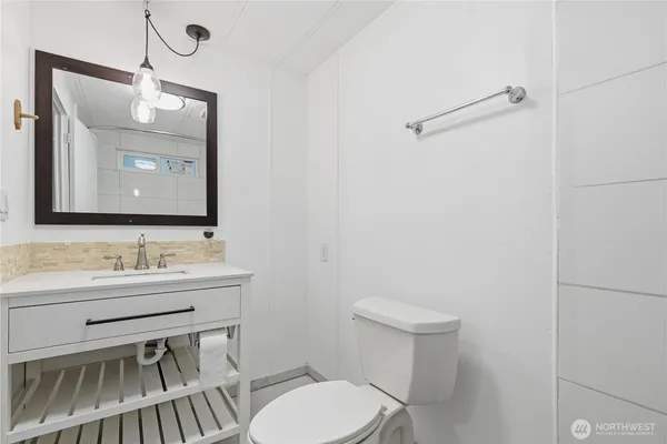 a bathroom with a toilet a sink and mirror