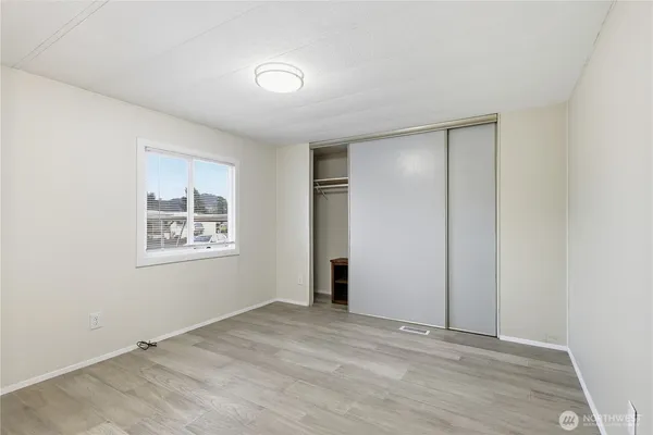 an empty room with windows and closet