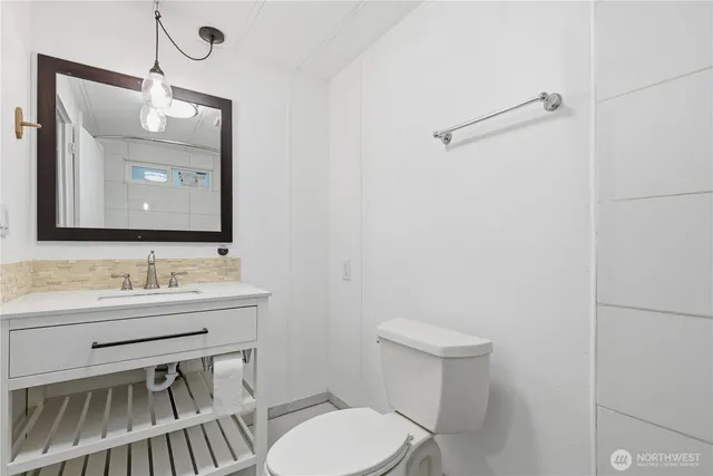 a bathroom with a toilet a sink and mirror