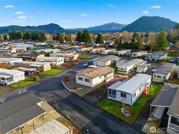 a picture of a city with lots of residential buildings ocean and mountain view in back