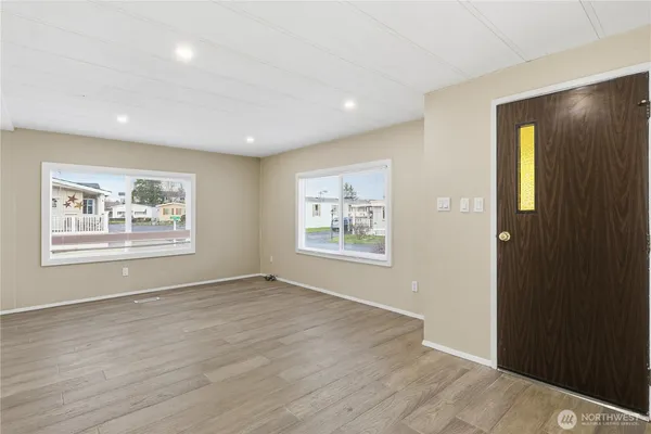 a view of an empty room with window and wooden floor