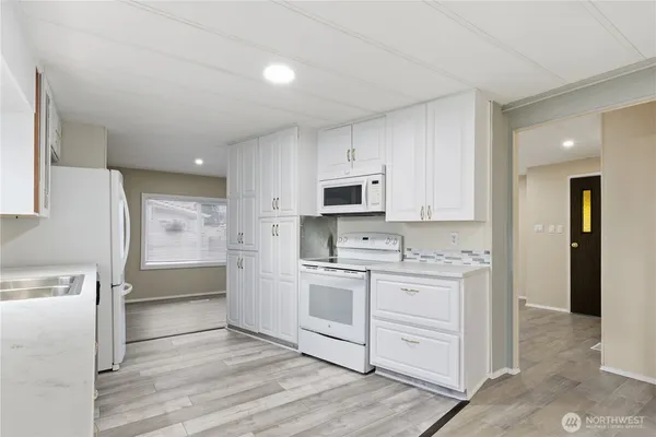 a kitchen with white cabinets and stainless steel appliances