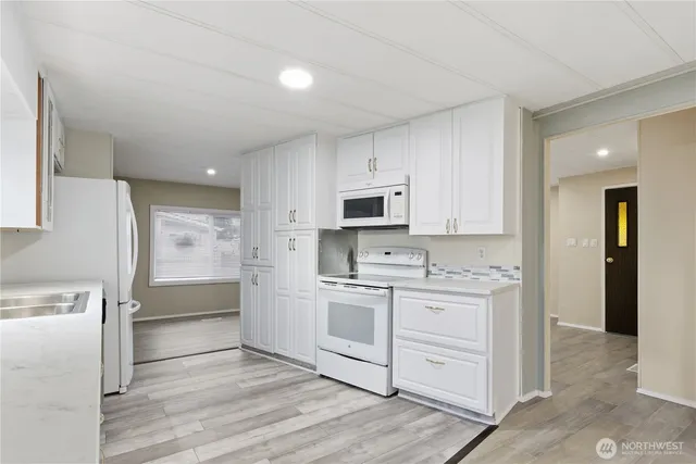 a kitchen with white cabinets and stainless steel appliances