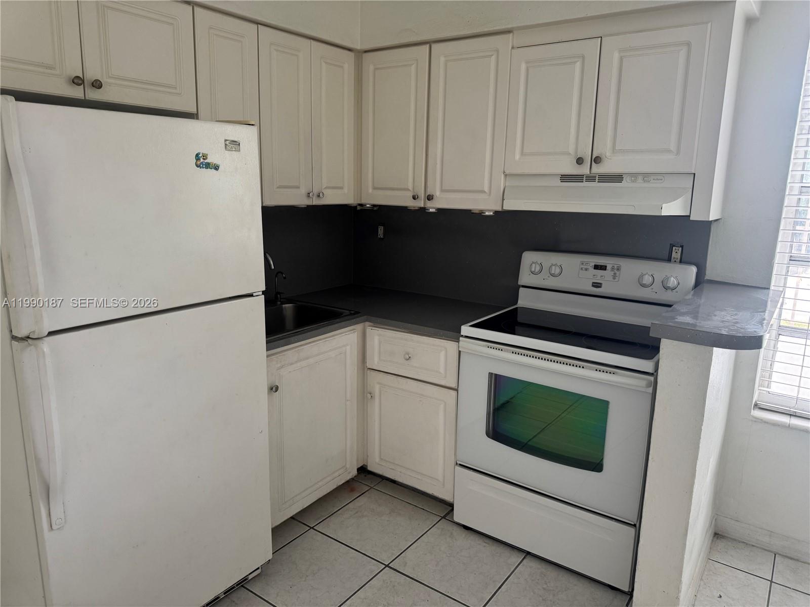 11 Southwest 32nd Avenue, Unit 4 Miami, FL 33135 - Photo 5 of 13 a white refrigerator freezer and a stove sitting inside of a kitchen