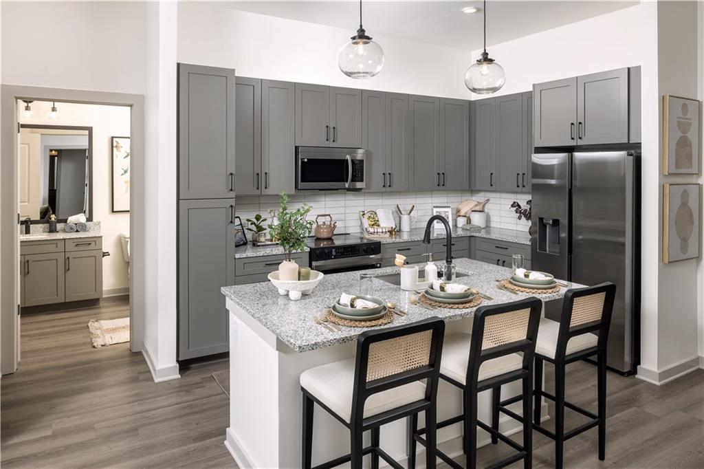 3108 McGinnis Ferry Road, Unit A6 Suwanee, GA 30024 - Photo 10 of 17 a kitchen with stainless steel appliances granite countertop a dining table and chairs
